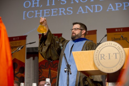 Person holding beaker on stage