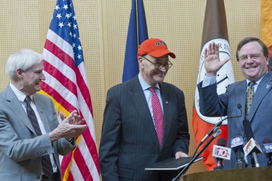 People posing with senator on stage