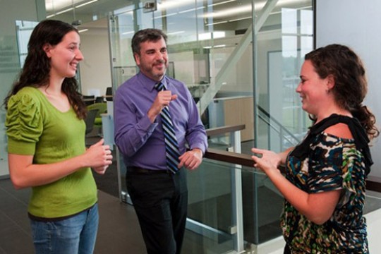 Three people talking inside