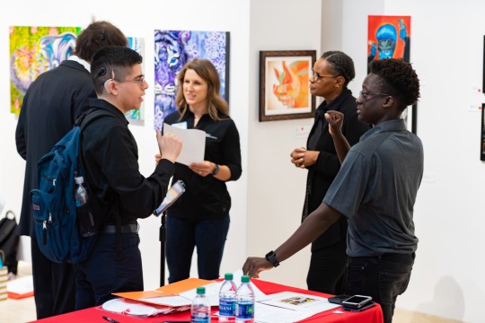 Students and employers conversing about resumes and job opportunities