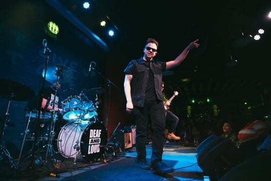 Man in sunglasses on stage at concert.