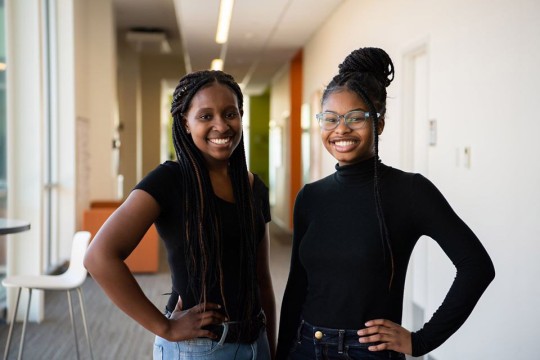two students standing side-by-side.