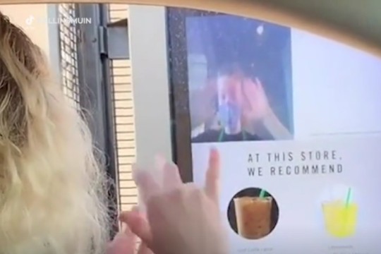 customer and employee using sign language at a Starbucks drive-through.