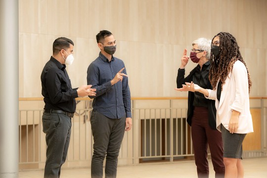 four people talking with sign language.