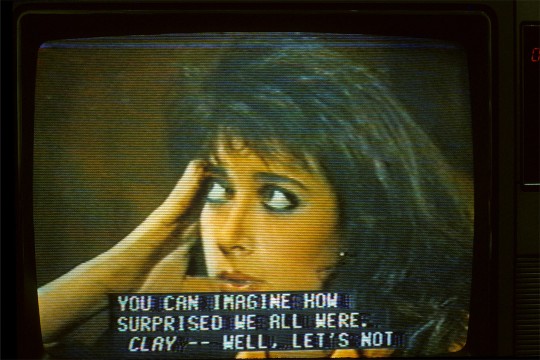TV in the 1980s showing a woman's face and closed captioning that reads: you can imagine how surprised we all were.