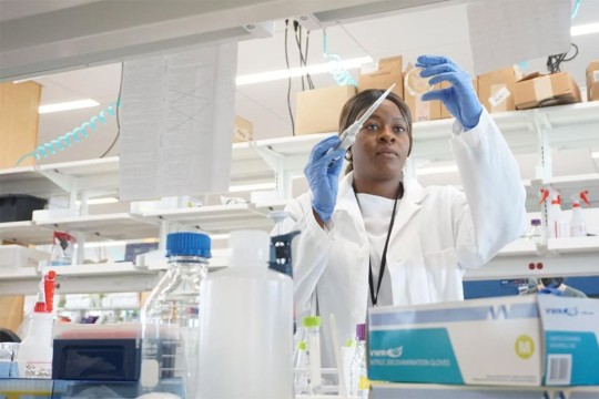 scientist using a pipette in a lab.