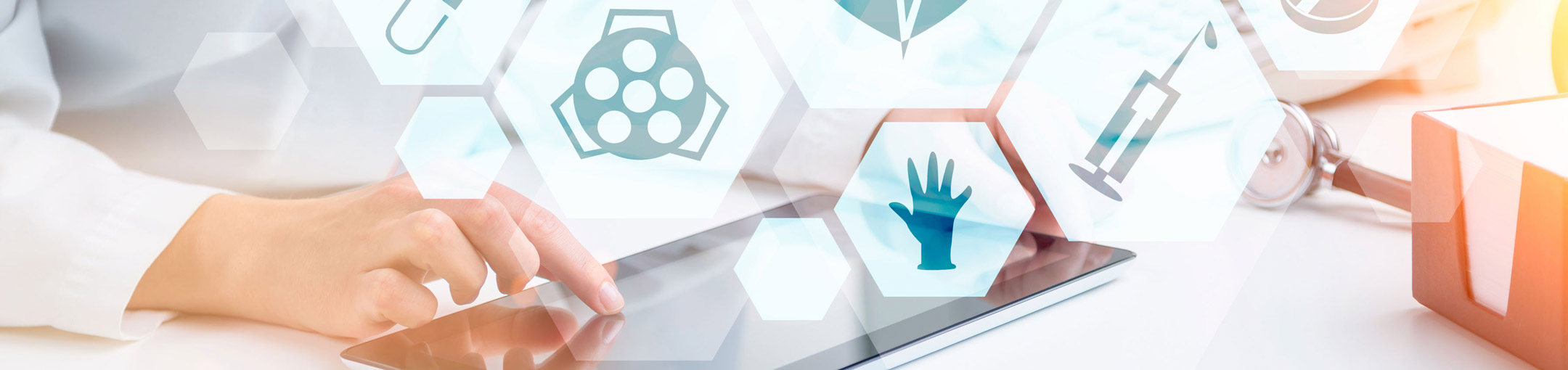 A hand uses a tablet computer. Various medical icons overlay the photo.