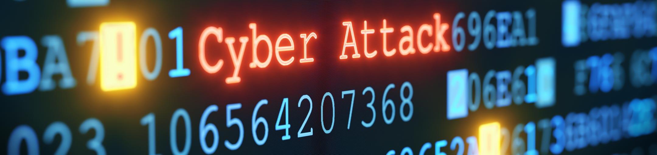 The words Cyber Attack appears in red on a screen of other blue text and numbers.