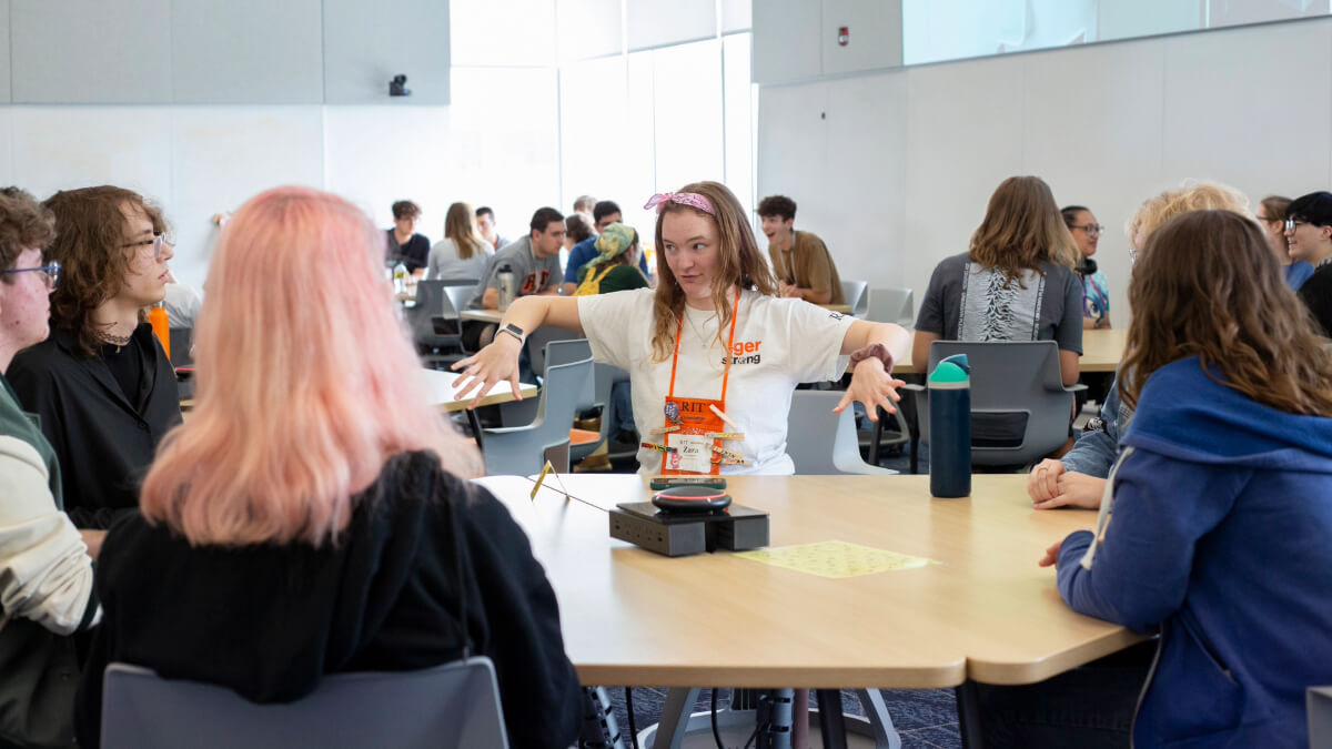 An Orientation Leader speaks to a table of students at a No Voice Zone event during Orientation week