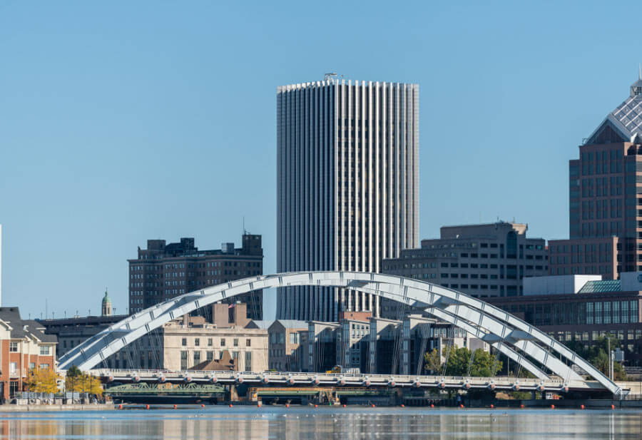 A photograph showing the Rochester skyline with a vibrant blue sky in the background.