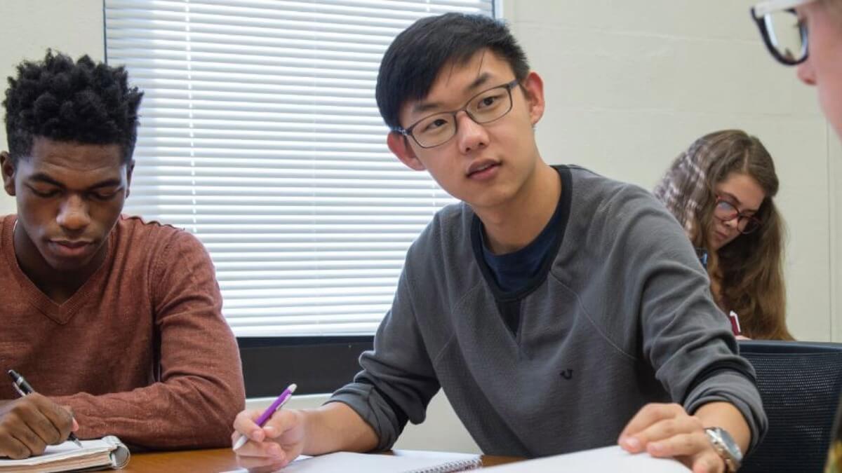 Three college students sitting at a table.