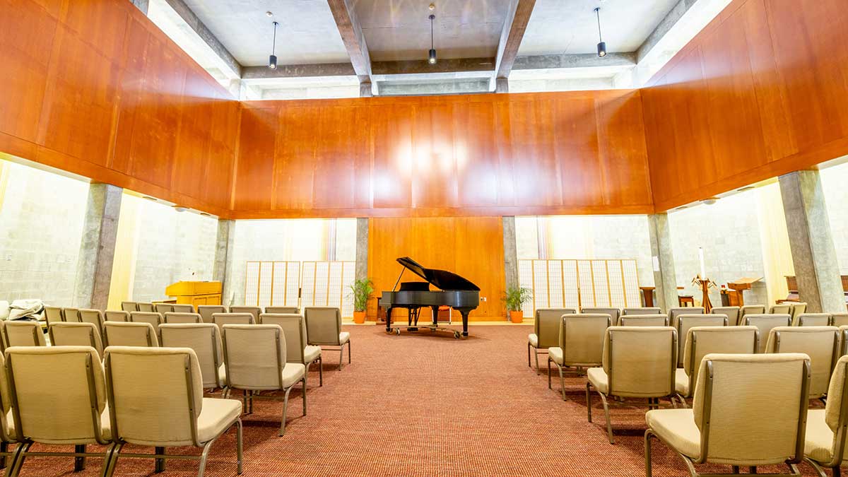 an intimate performance space with chairs and a grand piano.