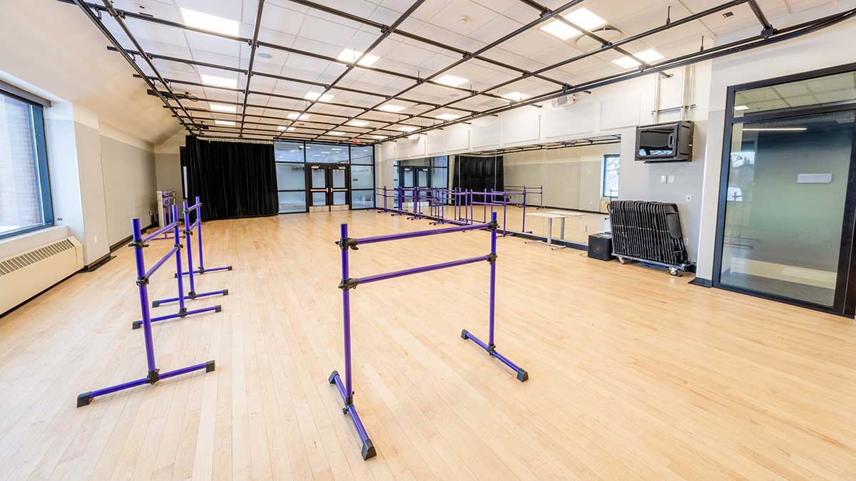 a dance studio with mirrored walls and individual barres.
