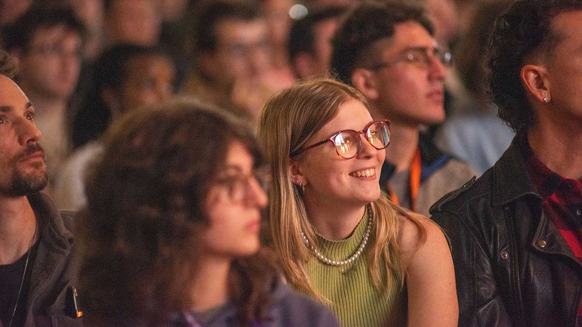 audience members watching a performance and smiling.