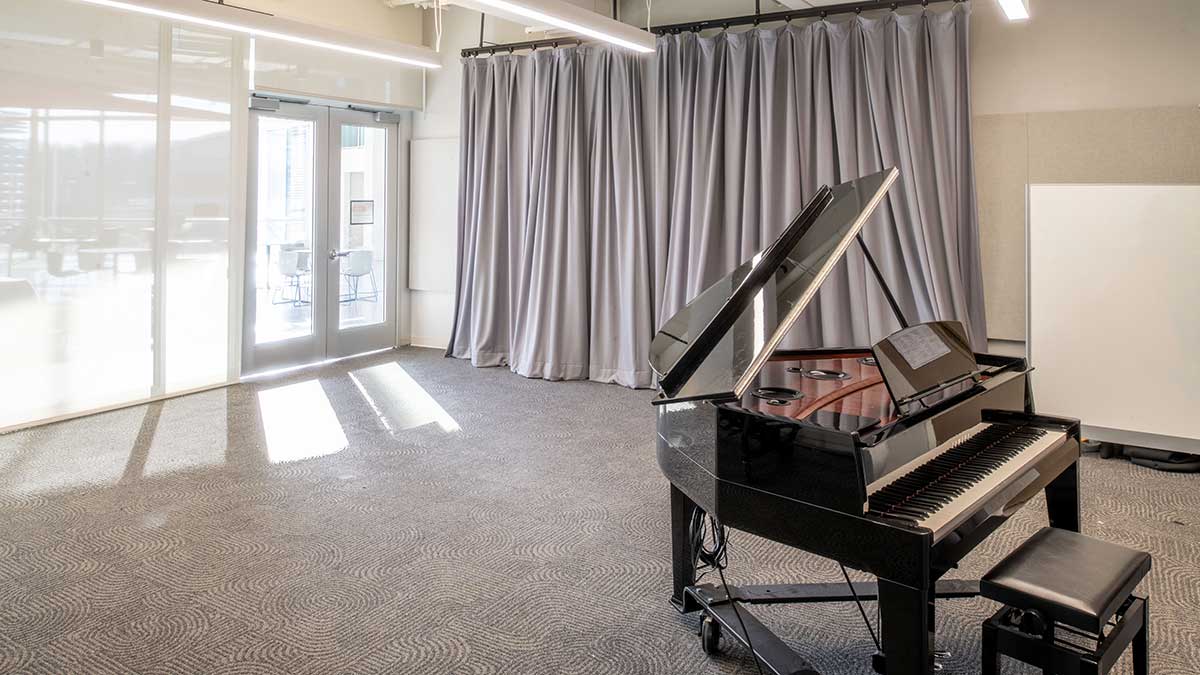 a practice room with a large curtain and a piano.