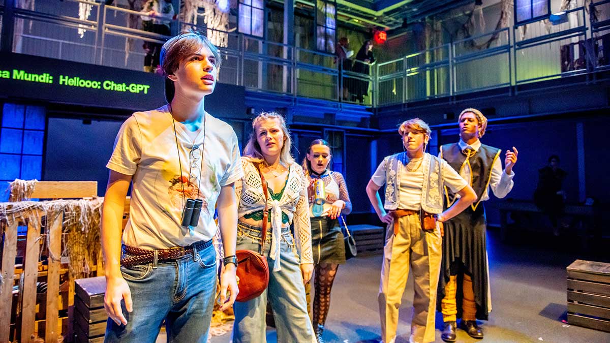 students performing a scene from a play on stage.