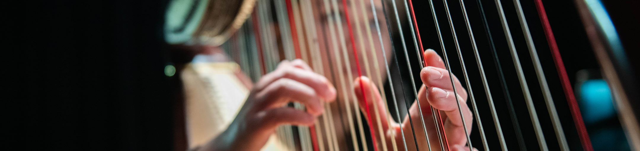 An RIT student playing the harp.