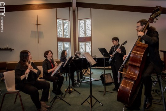 Group of musicians playing flute, clarinet, electric guitar and upright bass.