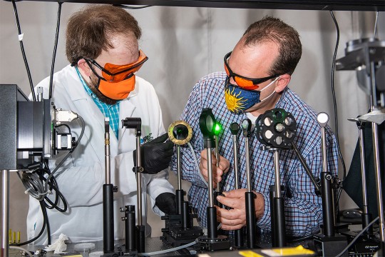 two researchers testing different lenses.