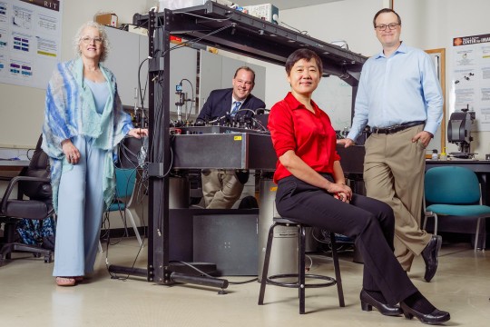 Research team poses with advanced photonics laboratory equipment at RIT.