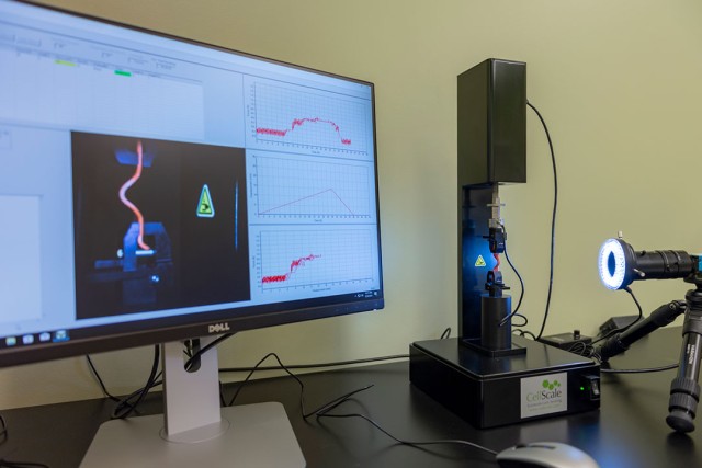 Biomedical device and computer monitor displaying data and graphs.