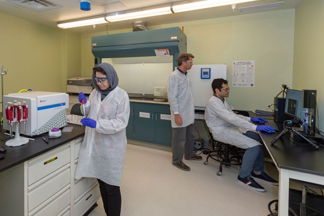 Steven Day and two graduate students working in a lab