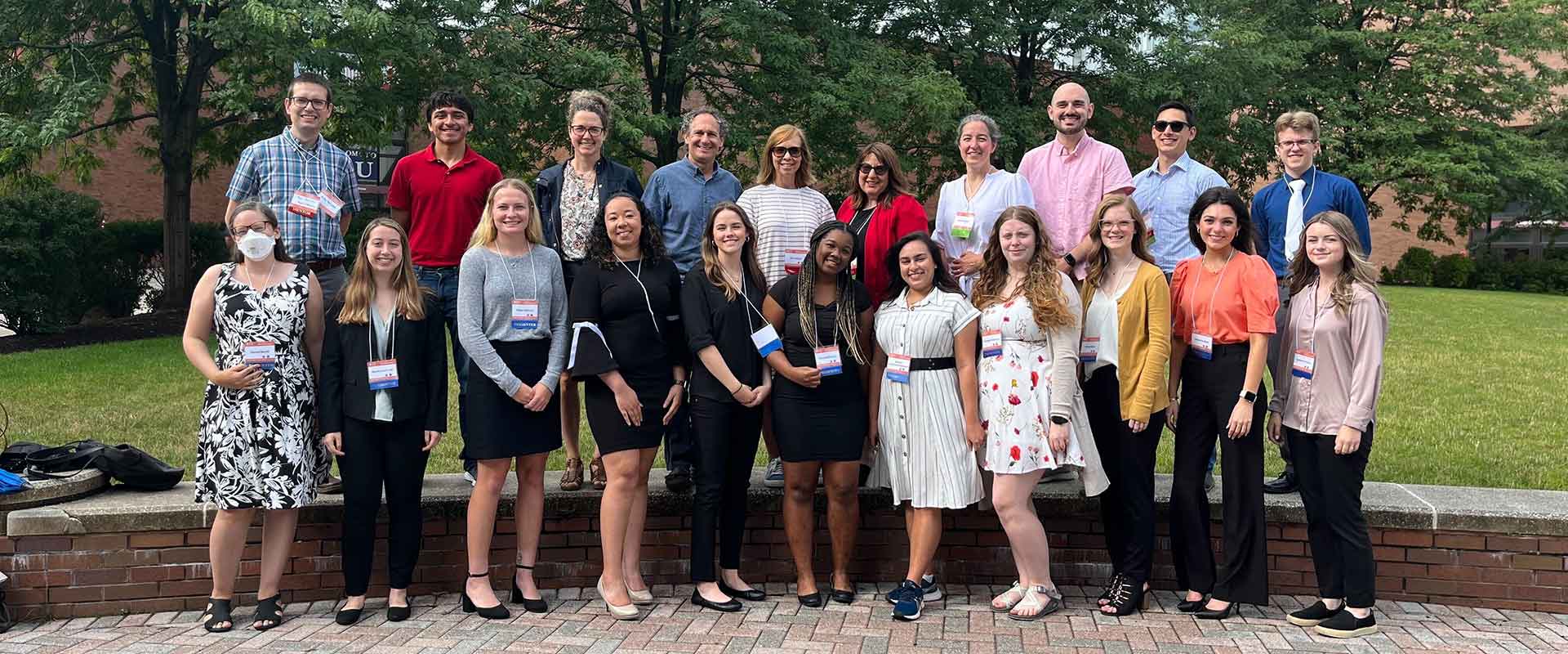 a group of students and researchers posing for a photo outdoors.