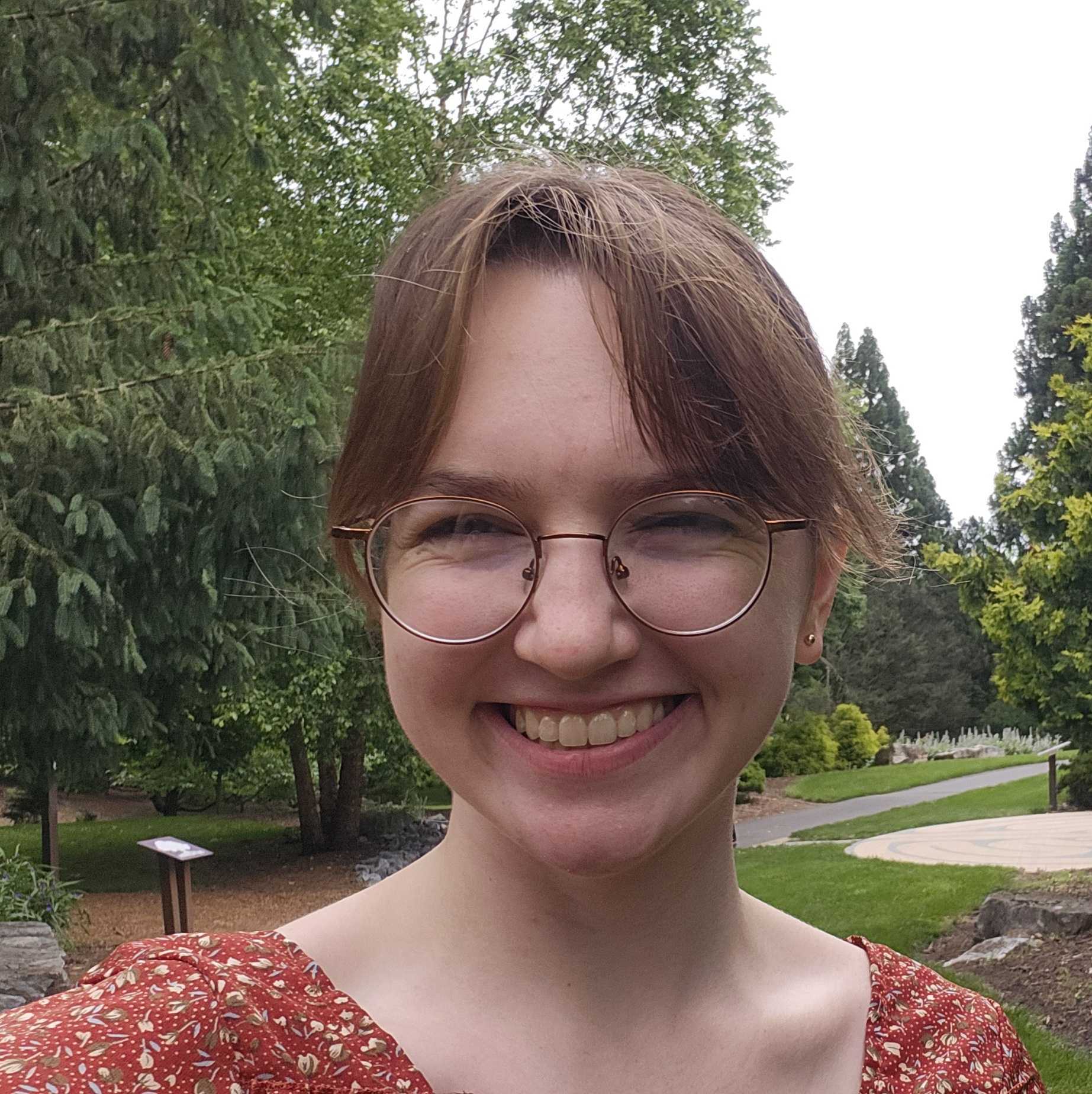 Headshot of Laura in front of some trees.