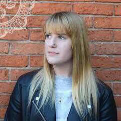 Kristina Chomiak standing in front of a brick wall.