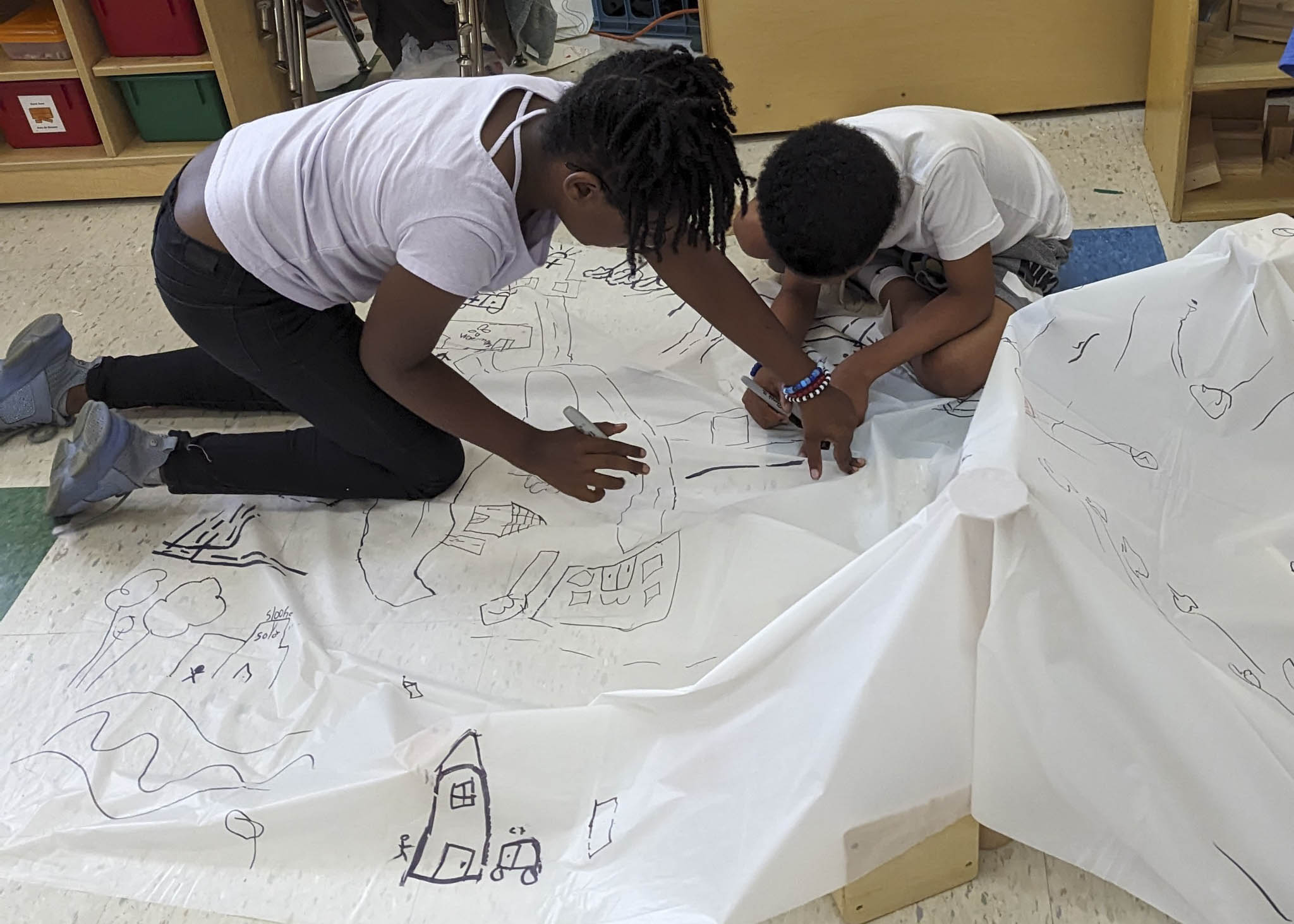Participants drawing on a sheet