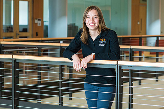 Co-op student posing for a photo leaning on a railing