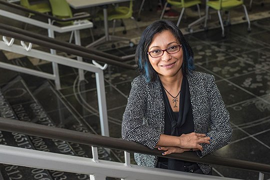 researcher posing on steps in the College of Science.