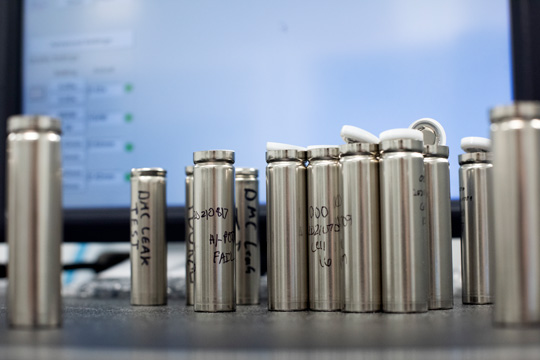 student researcher adjusts equipment that makes batteries.