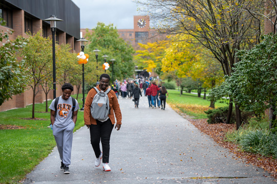two students sitting outside and laughing.