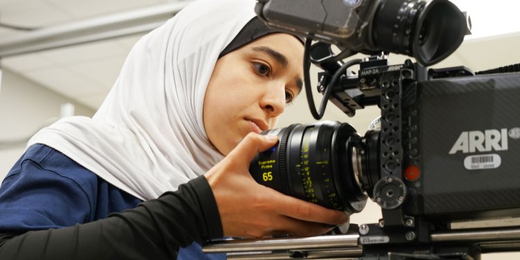 A group of students wearing masks using a cordless drill.