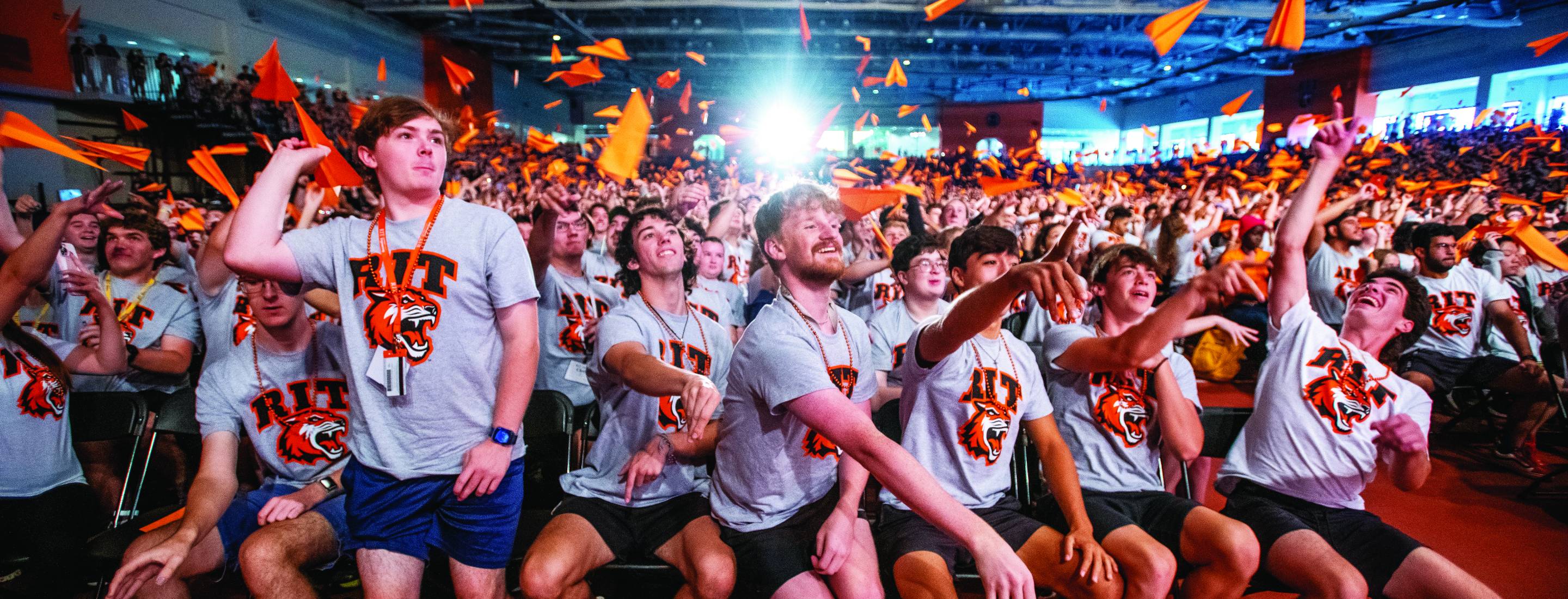 Two students working in a lab, one polishing copper pipes and the other has their hands in a hood.