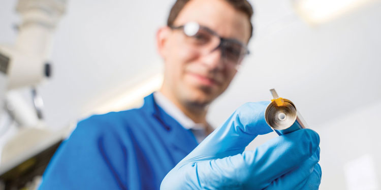 A group of students wearing masks using a cordless drill.