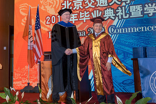 'Presidents of RIT and Beijing Jiaotong University Weihai shaking hands.'