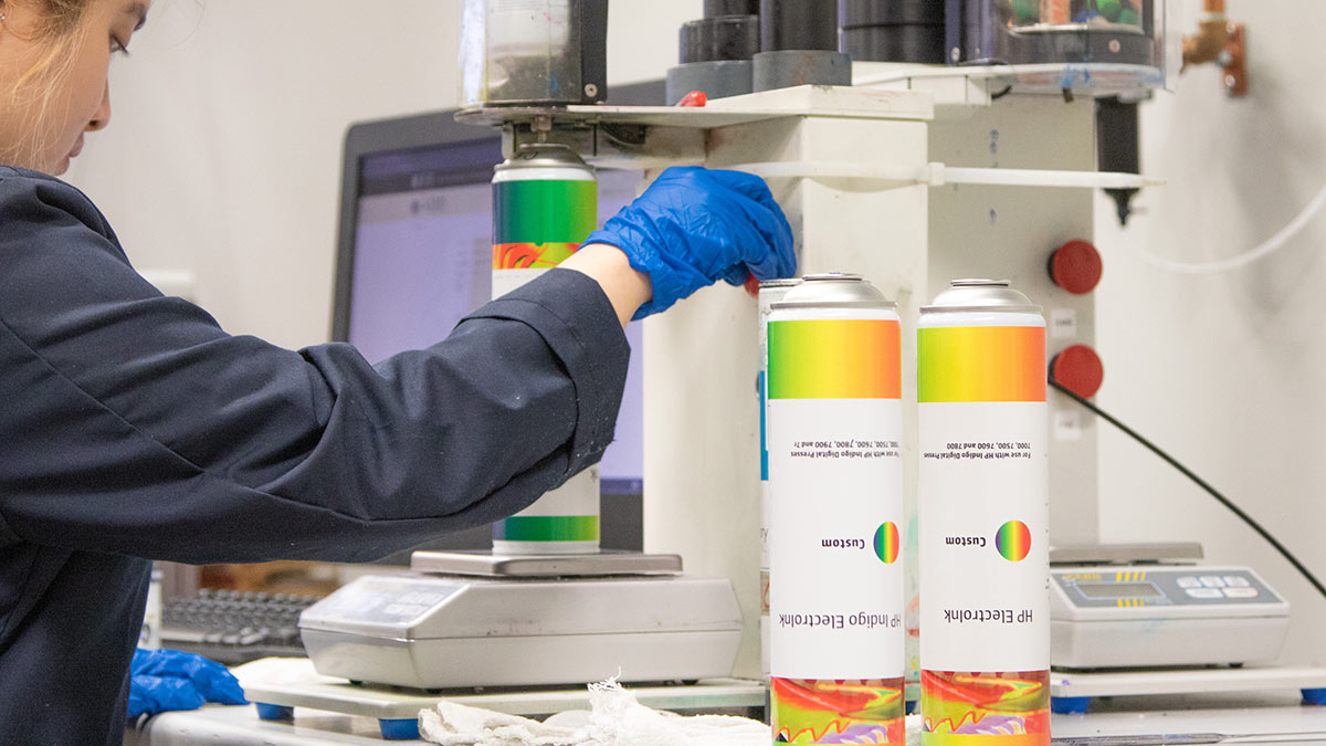 a lab worker weighing and mixing an ink canister.