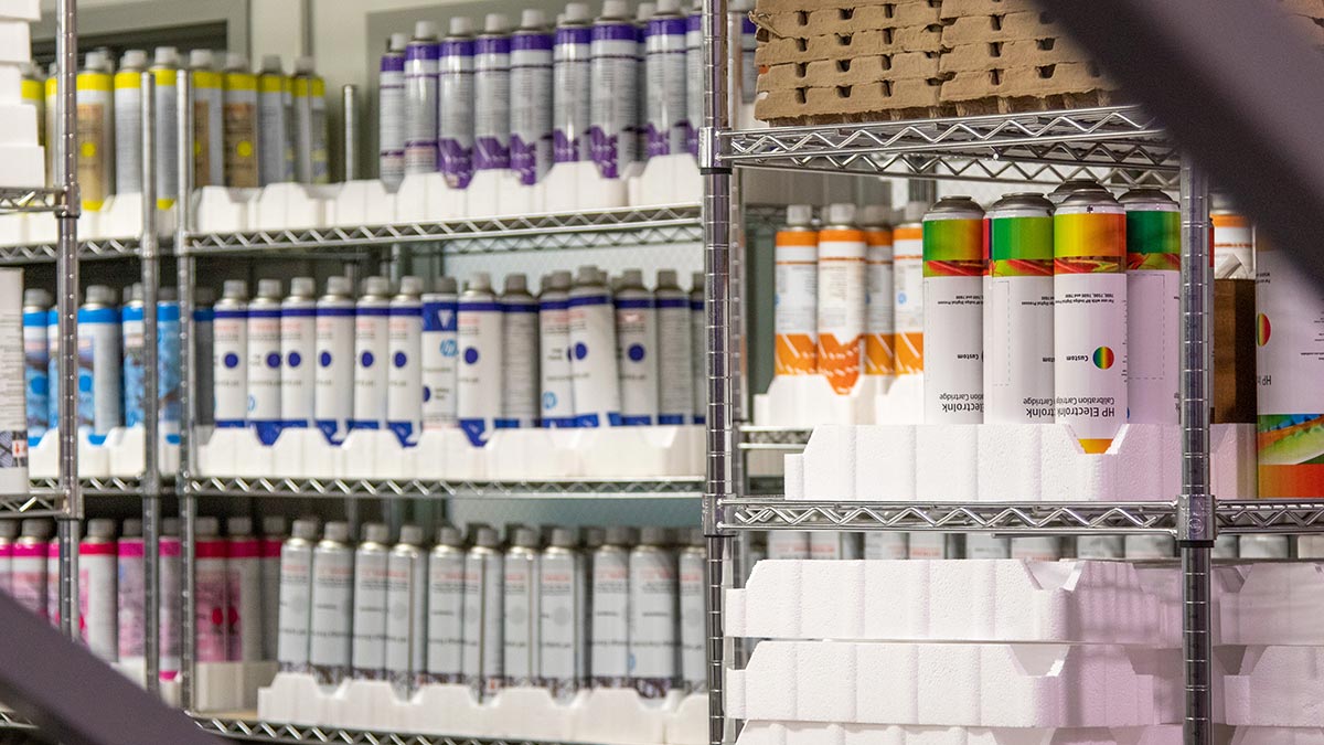 Canisters of different colored inks sitting on shelves.