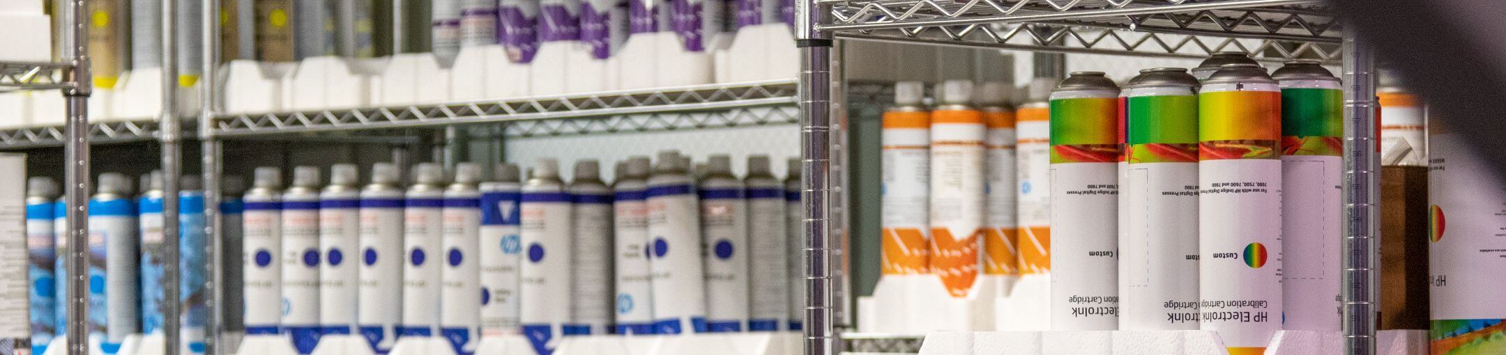 Canisters of ink sitting on shelves.