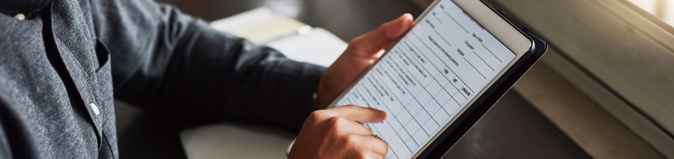 a person using a tablet with a survey form displayed on it