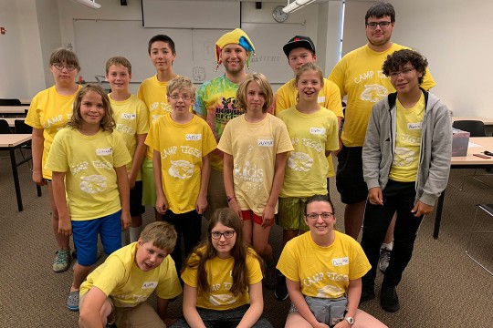 Group of K-12 and college students wearing yellow T-shirts.