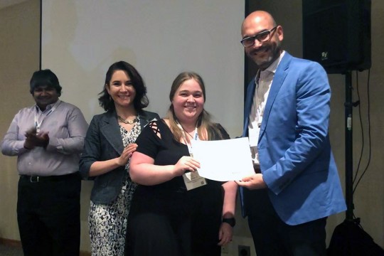 Student receives award while standing with professor.