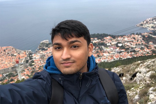 student standing on a mountain overlooking the city of Dubrovnik.