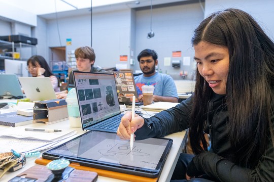 college student drawing on a tablet.