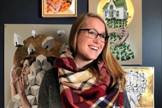 art teacher posing in front of some of her pieces.