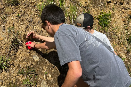 Two students collecting samples from the Black Hills