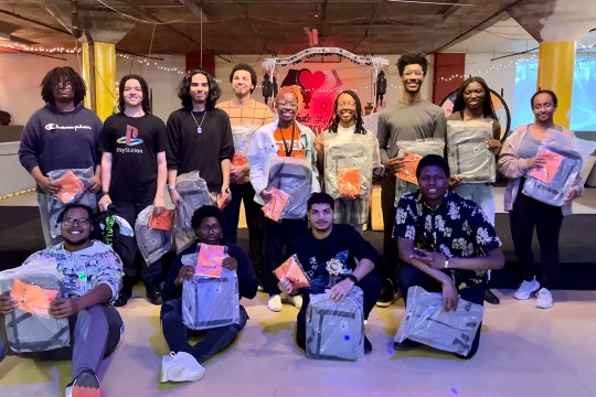 Students at roller rink holding up STEP swag and awards