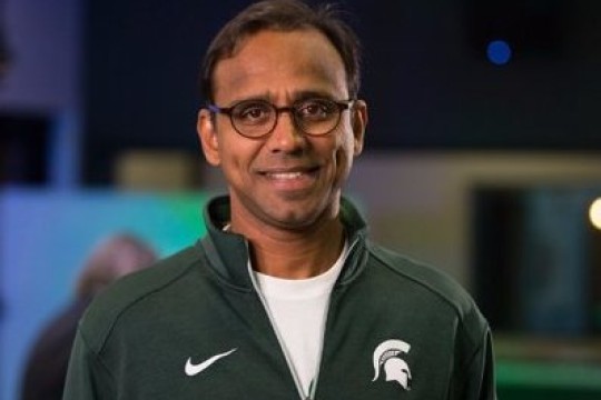 Man with glass and green jacket. 